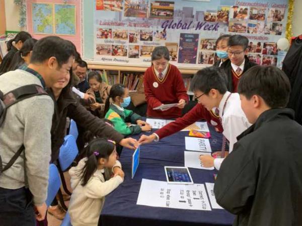 Students introducing various booth games to visitors during Information Day